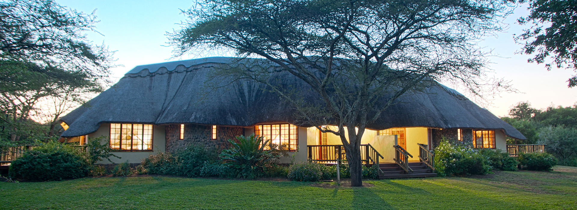 A tranquil view of Rhino River Lodge at sunset